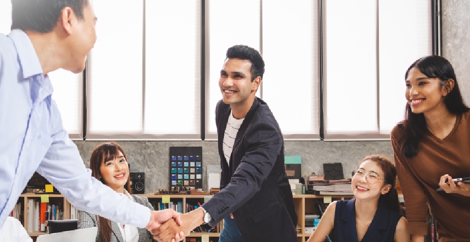 Colleagues in a corporate office setting, smiling