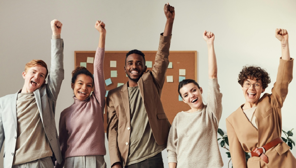 5 people with their fists up in the air and smiling