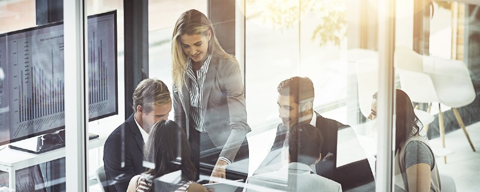 4 office workers sitting around a table in an office setting