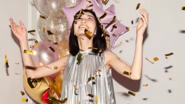 asian woman celebrating hands in the air confetti