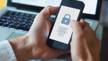 Person holding smartphone with padlock login screen.