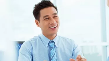 Man in a blue shirt smiling during a conversation.